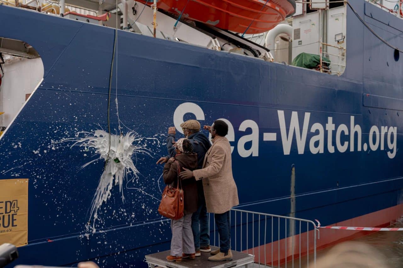 Naming ceremony of the Sea-Watch 5 in Hamburg. Activists from Lampedusa in Hamburg, Women and Exile and Refugees in Libya throwing a bottle against the hull of the ship.