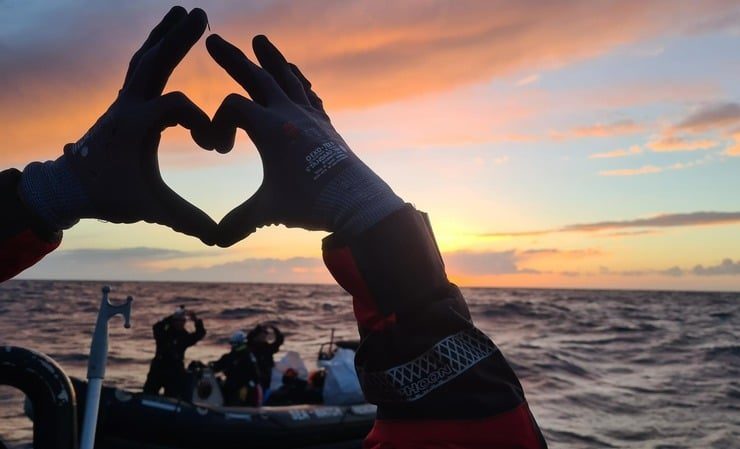 Hände zeigen ein Herz vor dem Horizont auf dem Mittelmeer